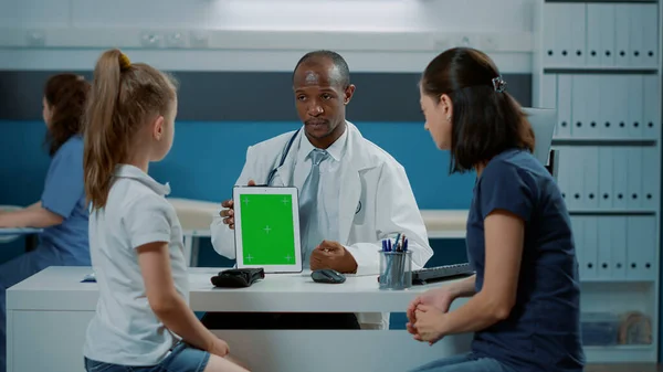 Afrikansk amerikansk medic håller grön skärm på digital surfplatta — Stockfoto