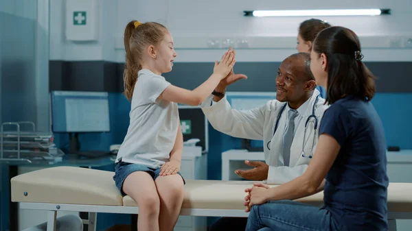 Médico afroamericano dando highfive a niño pequeño —  Fotos de Stock