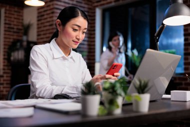 İş kadını sosyal medya platformunda cep telefonu kullanarak mesaj gönderiyor.