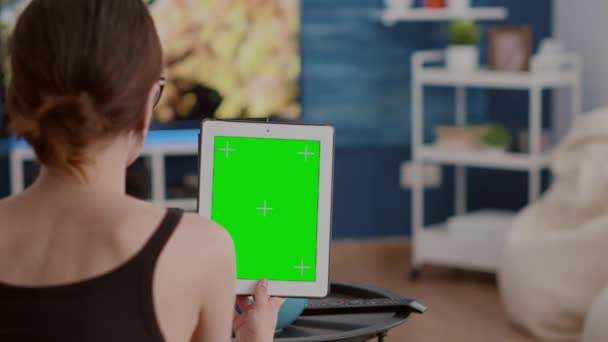온라인 회의나 그룹 영상 통화에서 녹색 화면이 달린 수직 디지털 태블릿을 들고 있는 젊은 여성의 모습 — 비디오