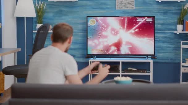 Man holding controller playing action space shooter on console zklamaný, protože prohrává online hru — Stock video