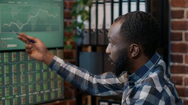 Erkek finans analisti ön x ticaret piyasa rakamlarına bakıyor