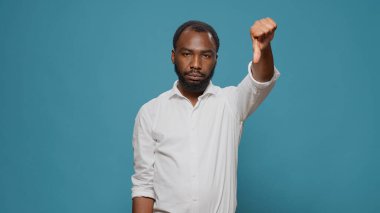 Negatif kişi stüdyoda baş parmak hareketi yapıyor.