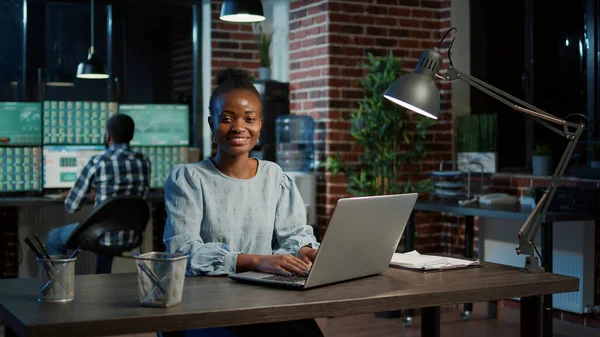 Portret van sales consultant aan de hand van handelsmarktstatistieken op laptop — Stockfoto