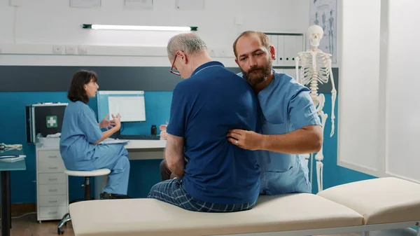 연로 한 환자의 뼈를 깨는 시술을 사용하는 물리 치료사 — 스톡 사진
