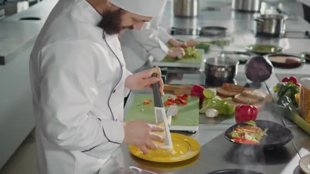 Chefe masculino ralando queijo parmesão no ralador de cozinha — Vídeo de Stock