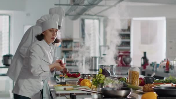 Женщина-повар готовит профессиональное кулинарное блюдо на сковородке — стоковое видео