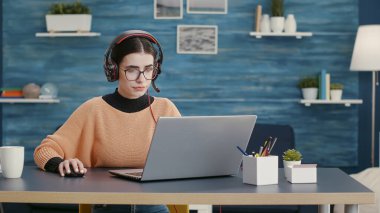 Çevrimiçi video konferansında kulaklıkla konuşan genç kişi