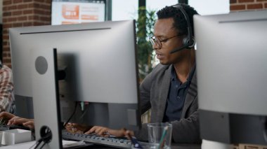 African american employee using headset at customer service clipart