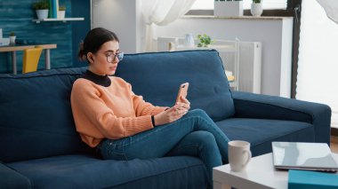 Uzaktan görüntülü konuşmak için akıllı telefonu kullanan genç.