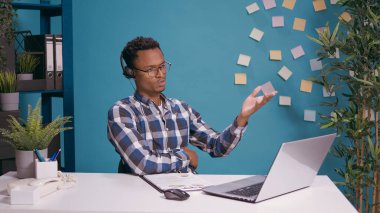 Satış temsilcisi müşteri hizmetlerini aramak için kulaklık kullanıyor.