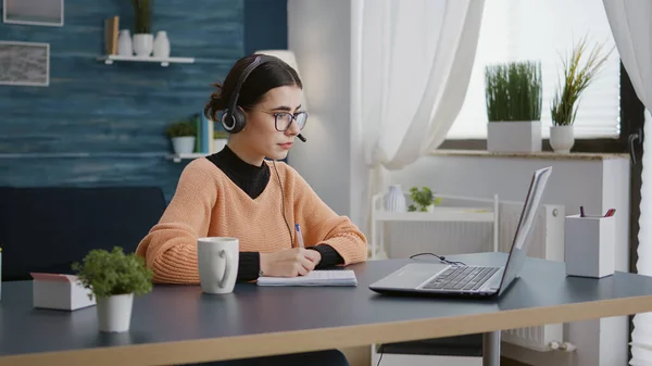 University student listening to online school class on laptop