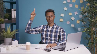 Ofis masasında işaret parmağıyla işaret eden ciddi biri.