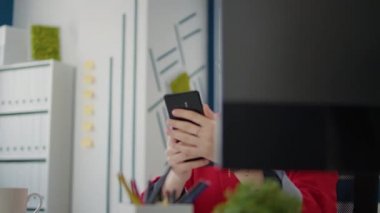 Proje yöneticisi cep telefonundaki kısa mesaja bakıyor