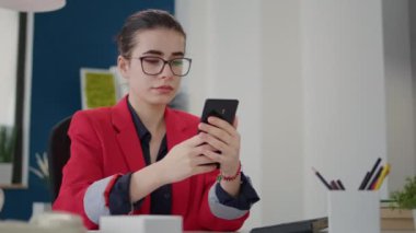 Şirket muhasebecisi akıllı telefondan mesajları kontrol ediyor.