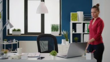 Dizüstü bilgisayardaki satış istatistiklerini analiz eden yönetici asistanının portresi