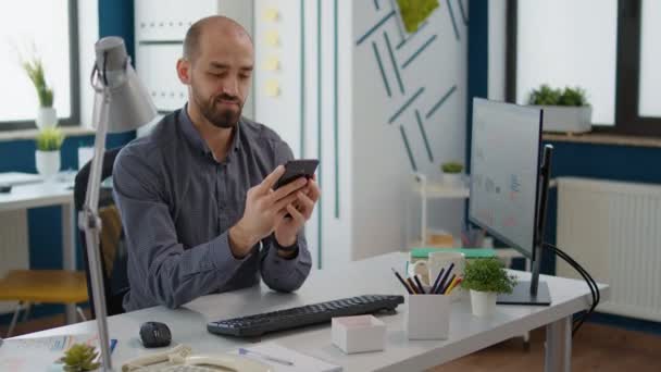 Trabalhador de escritório usando smartphone para navegar na internet e mensagens de texto — Vídeo de Stock