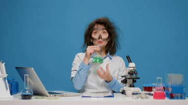 Çılgın kimyager laboratuvar deney şişesini inceliyor ve deli gibi davranıyor.