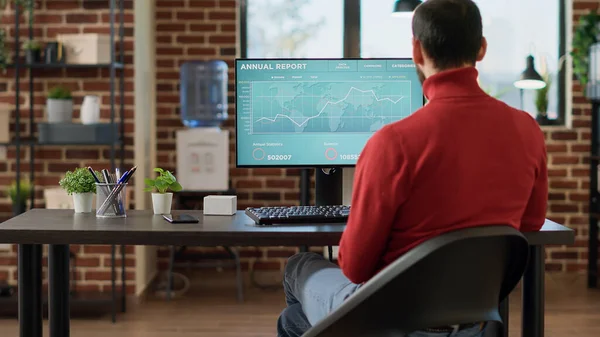 Proje yöneticisi ön eksantre çizelgeleriyle bilgisayara bakıyor