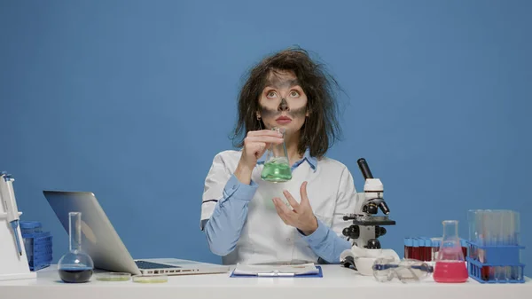 Šílený zábavný chemik analyzuje laboratorní kádinku a chová se šíleně — Stock fotografie