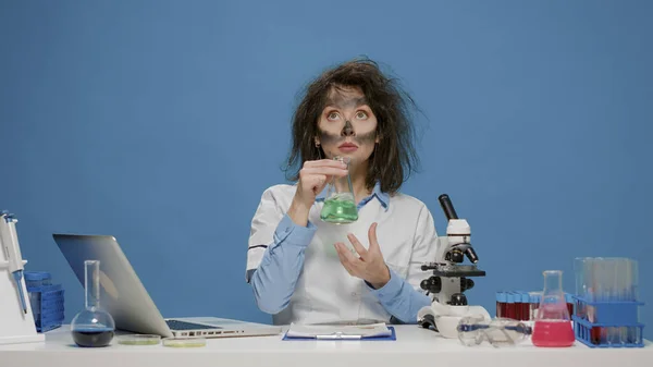 Químico divertido loco analizando vaso de precipitados de laboratorio y actuando demente —  Fotos de Stock