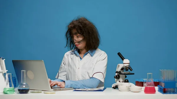 Retrato de una química loca trabajando en un portátil en el escritorio —  Fotos de Stock