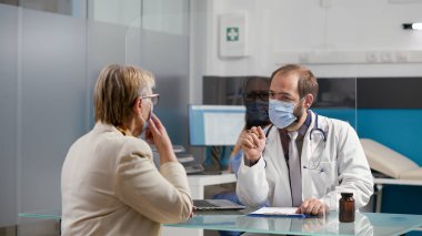 Erkek doktor reçeteli ilaç vermek için kontrol dosyalarına not alıyor