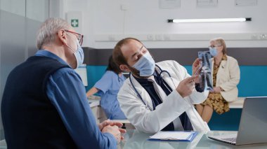 Radyografi analizi yapan pratisyen hekim ofiste sonuç veriyor.