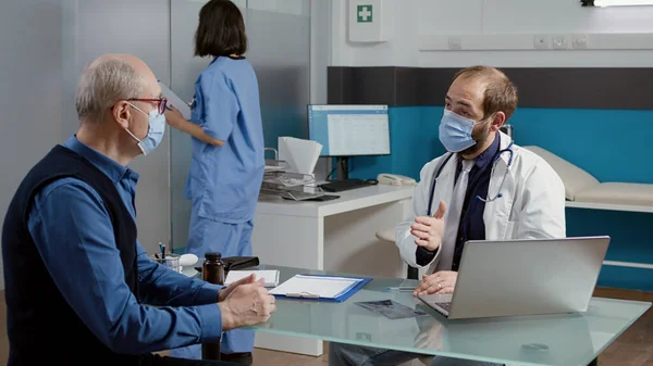 Male doctor doing medical consultation with old patient — Stock Photo, Image