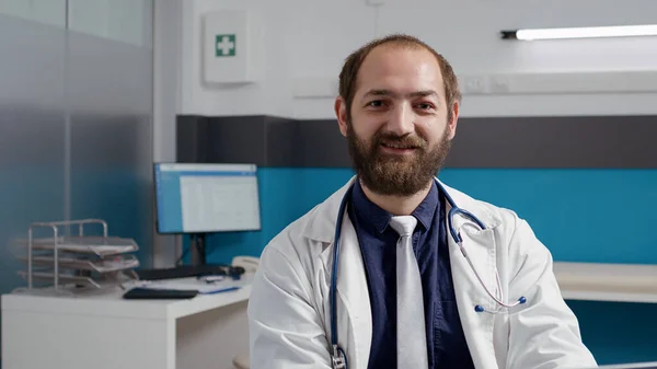 Retrato de clínico geral trabalhando no laptop em consultório médico — Fotografia de Stock