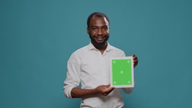 Yeşil ekranlı dijital tablet tutan neşeli kişi