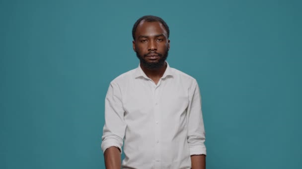 Portrait of young man showing thumbs up and thumbs down sign — Stok Video