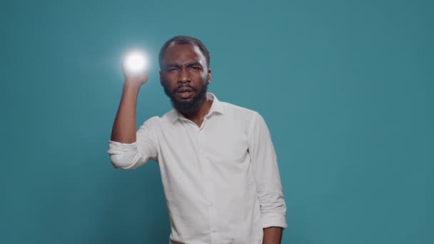 Pessoa confusa usando lanterna para procurar por fonte de som misterioso — Vídeo de Stock