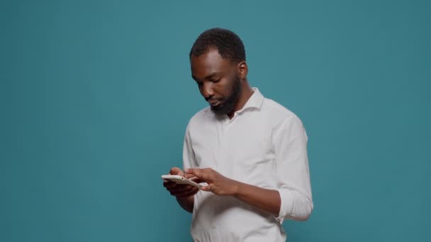 Африканский американец, работающий над современным смартфоном — стоковое видео