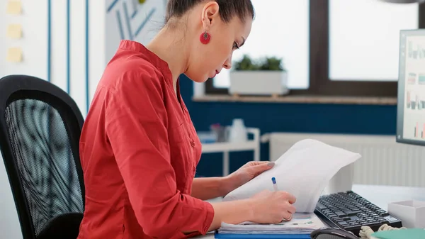 Female accountant taking notes on business documents — Stock Photo, Image