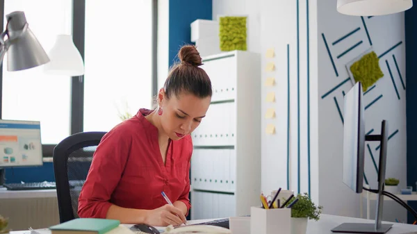 Company employee taking notes on charts documents — Stock Photo, Image