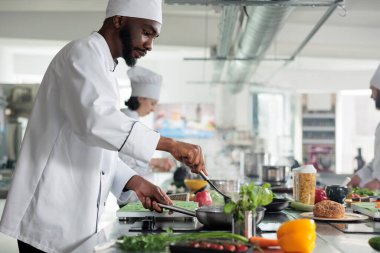 Yemek endüstrisi çalışanı profesyonel mutfakta yemek hazırlıyor..