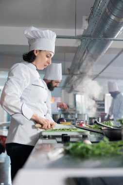 Restoran çalışanı taze otlar ve sebzeler doğradı. Güzel yemeklerde sunulan gurme yemeklerinde kullanılacak..