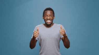 Neşeli pozitif adam kameraya baş parmak hareketi yapıyor.