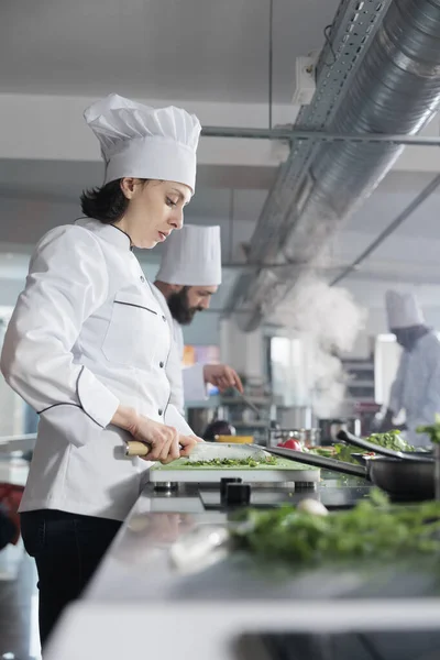 El empleado de la cocina del restaurante corta hierbas y verduras frescas para ser utilizadas en platos gourmet servidos en restaurantes finos. —  Fotos de Stock