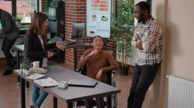 Çok yönlü çalışanlardan oluşan bir ekip beyin fırtınası yapıyor ve gülüyor.