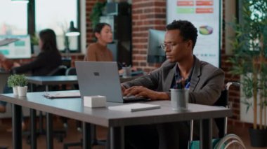 Afrikalı Amerikalı adam dizüstü bilgisayardaki mali istatistikleri analiz ediyor.