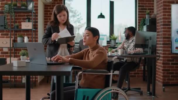 Ασιάτισσα γυναίκα σε αναπηρική καρέκλα ιδέες brainstorming με συνάδελφο — Αρχείο Βίντεο
