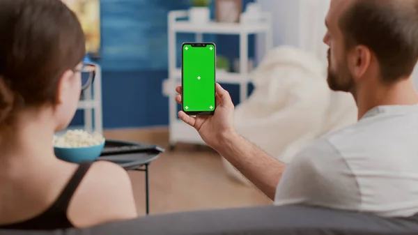 Zbliżenie pary trzymającej pionowy smartfon z zielonym ekranem mówiącym o zawartości influencera vlog — Zdjęcie stockowe