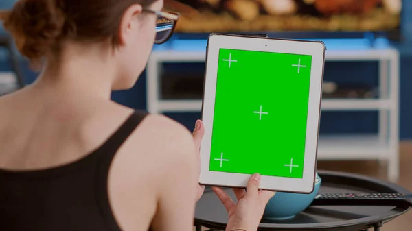 Primo piano della giovane donna con tablet digitale verticale con schermo verde in conferenza online o videochiamata di gruppo — Foto Stock