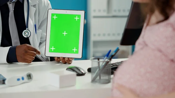 Médecin tenant tablette numérique avec fond vert — Photo