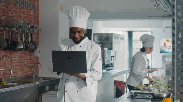 非洲裔美国厨师在笔记本电脑屏幕上做菜 — 图库照片