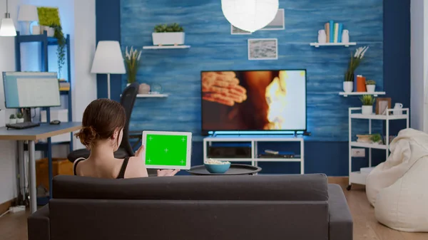 Trépied statique de la jeune femme tenant tablette numérique avec écran vert regarder webinaire — Photo