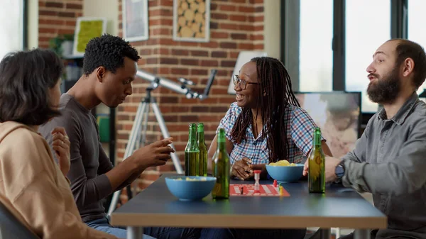 Çok ırklı bir grup insan masa oyunlarıyla eğlenmek için toplanıyor.