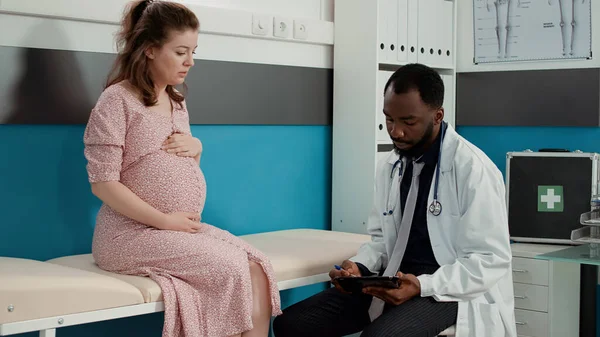 Obstetriker antecknar på digital tablett om moderskap — Stockfoto